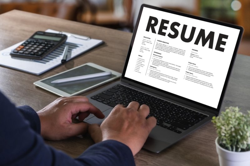 man building his resume on his laptop