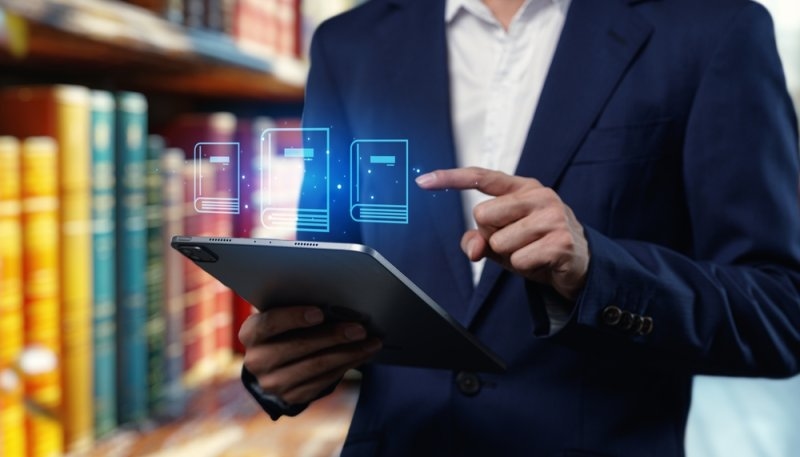 Man using a tablet to access digital resources in a modern library