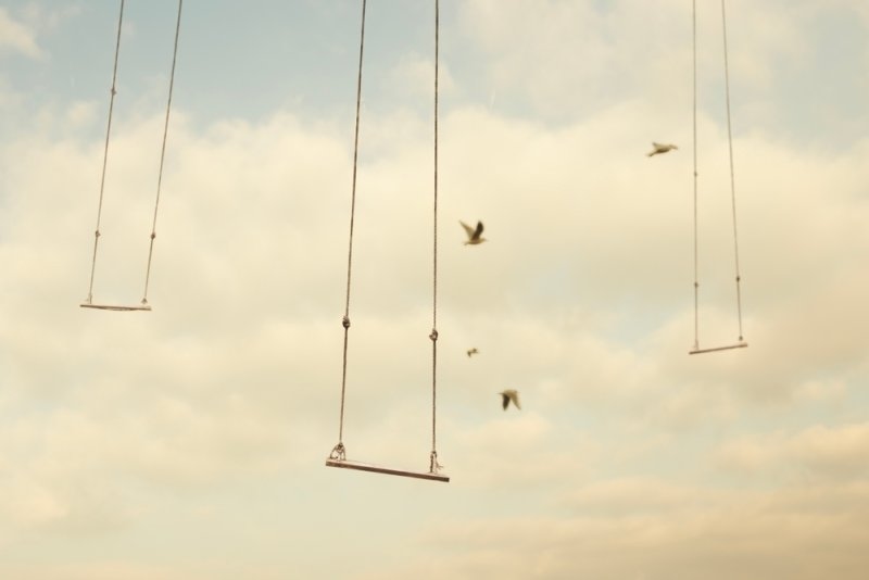 Surrealist artwork of floating swings among clouds representing imagination