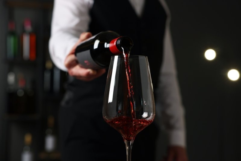 Bartender pouring red wine in a wine glass