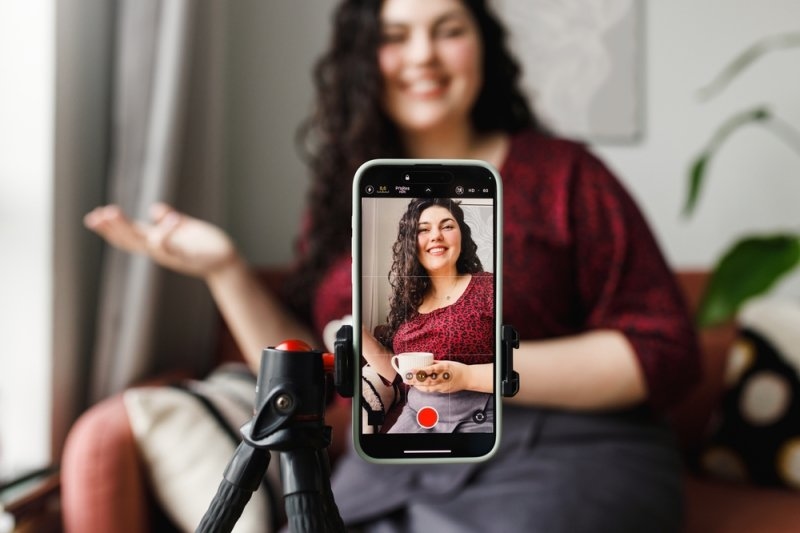 Macro influencer recording form her phone mounted on a tripod 