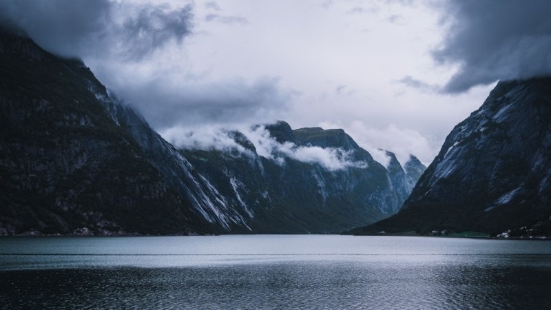  scenic view of a fjord in Norway with foggy steep mountains