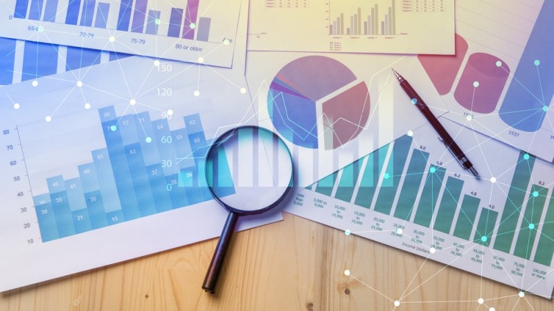 Magnifying glass and documents with analytics data