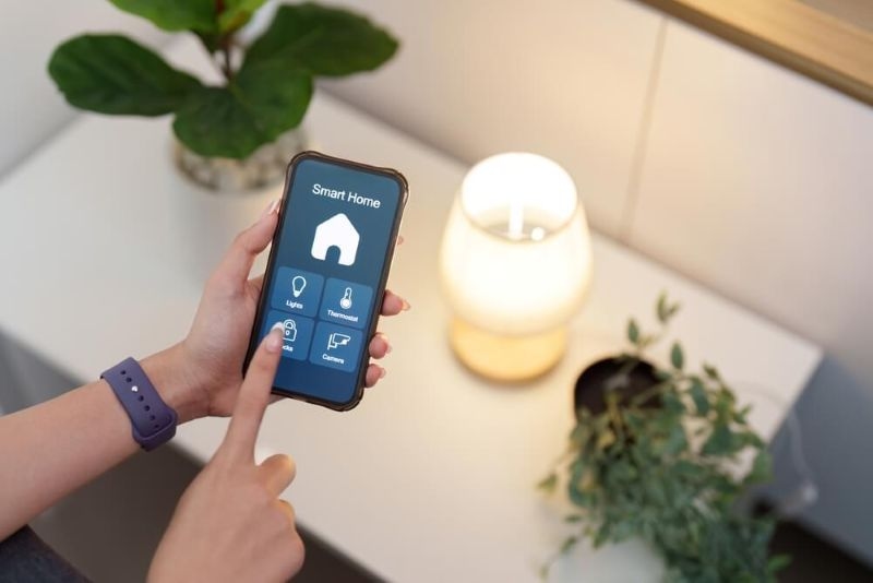 User controlling smart home lighting with smartphone