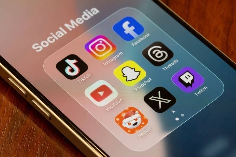 Smartphone screen showing popular social media app icons including TikTok, Instagram, Facebook, Snapchat, YouTube, Threads, Twitch, Reddit, and X.