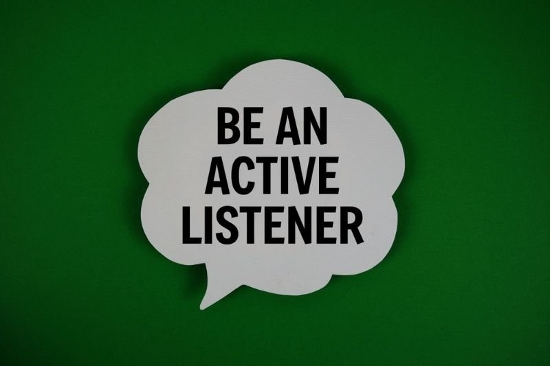 A speech bubble sign reads “BE AN ACTIVE LISTENER” against a green background, promoting communication skills.