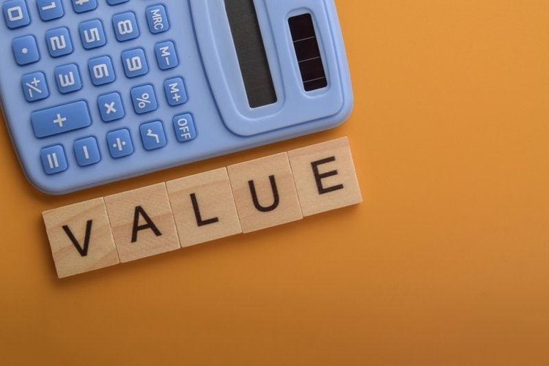 Calculator and wooden letters representing business value.