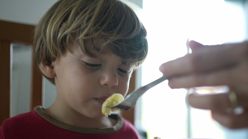 Adult supervising toddler during mealtime