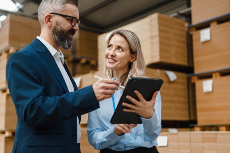 Supplier taking to his warehouse manager checking goods