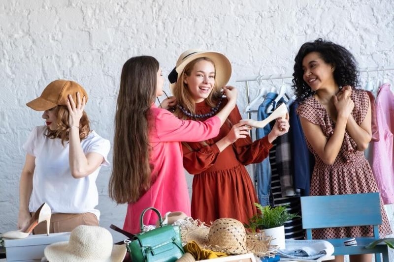 Women exchanging clothes , hats and wearables at a swap party event