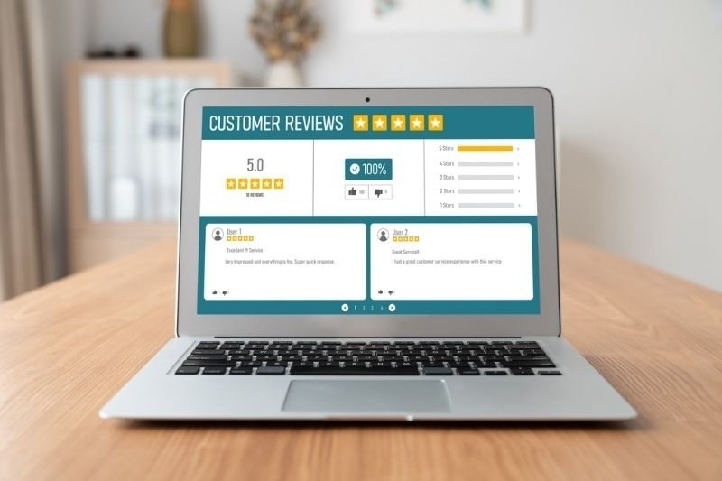 A laptop screen shows a customer review and rating interface with five-star ratings.