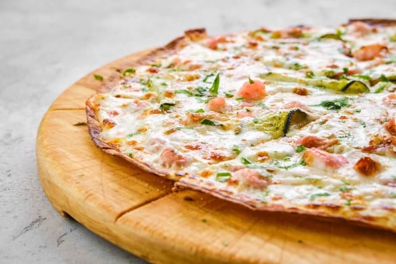 thin crust pizza with zucchini and shrimps toppings