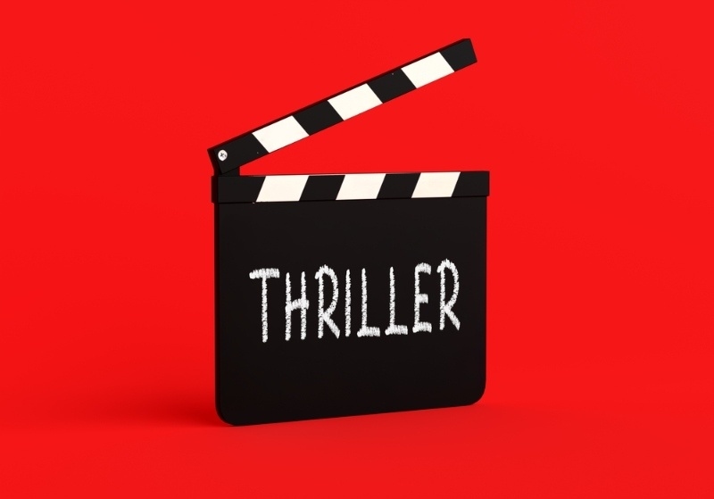 Black movie clapperboard with the word ‘Thriller’ on a bright red background.