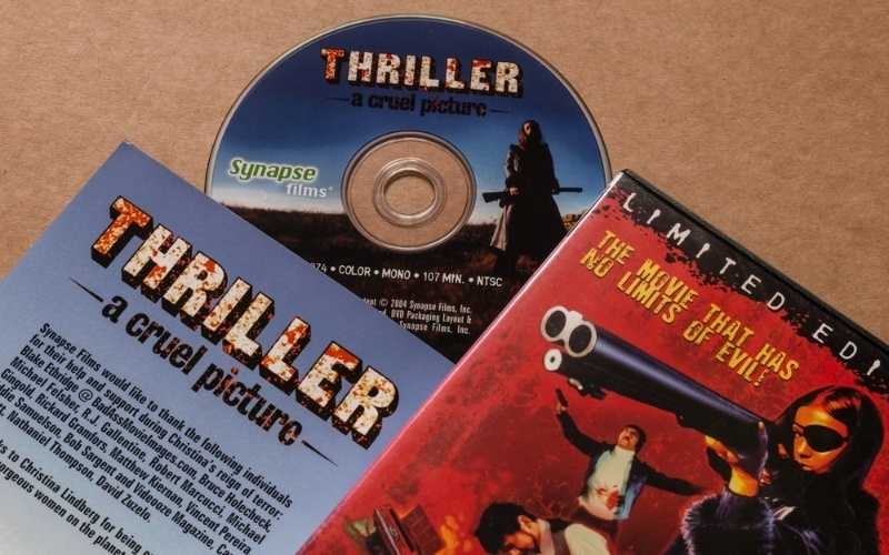 Collection of thriller movie DVD covers, disc, and booklet displayed on a table.
