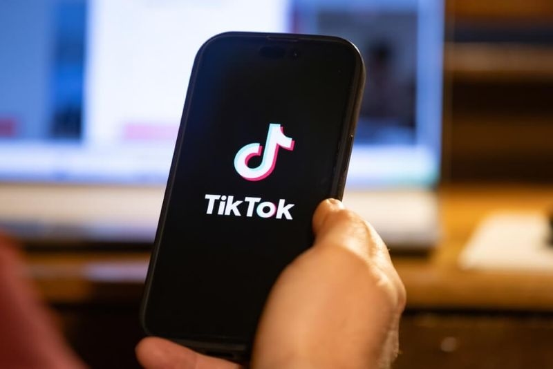 man using phone with tiktok application opening on the phone