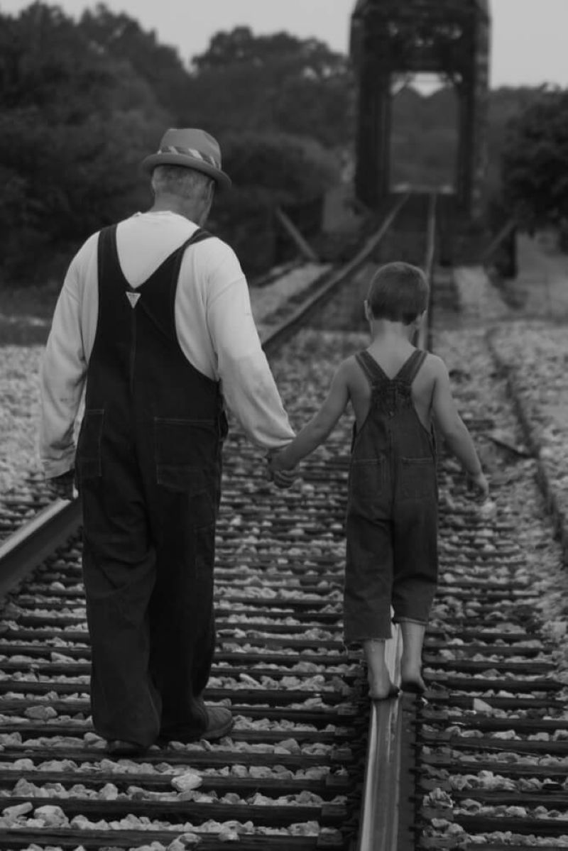old man and child walking holding hands