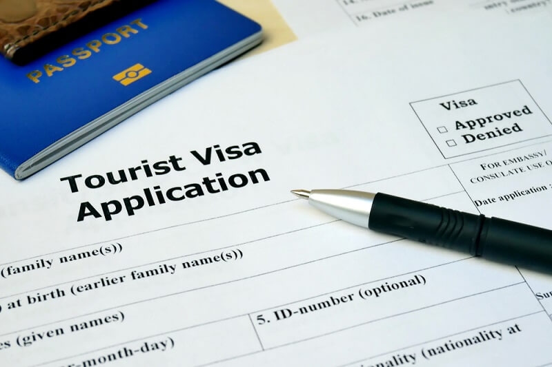 tourist visa application with pen and passport