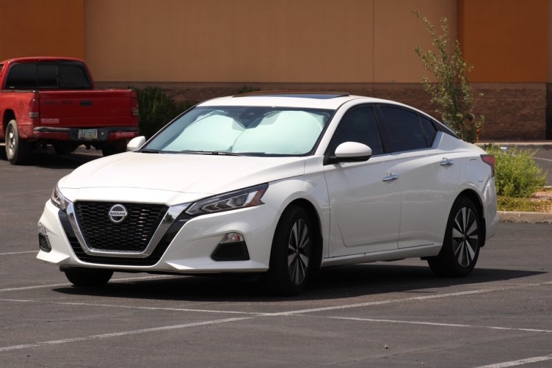 White Nissan Altima sedan parked outdoors.