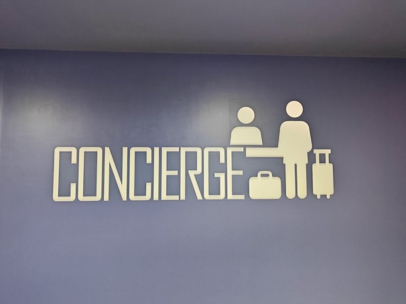 Concierge sign featuring luggage icons on purple wall