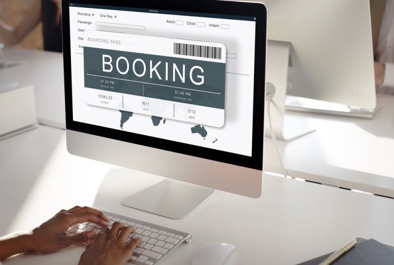 Computer displaying a flight booking form with a boarding pass.