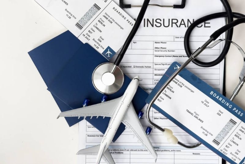 Medical travel insurance papers with toy plane  kept on top