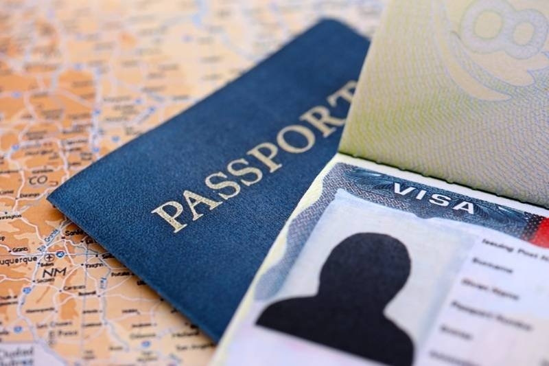 US visa in passport on United States geographical map close up.