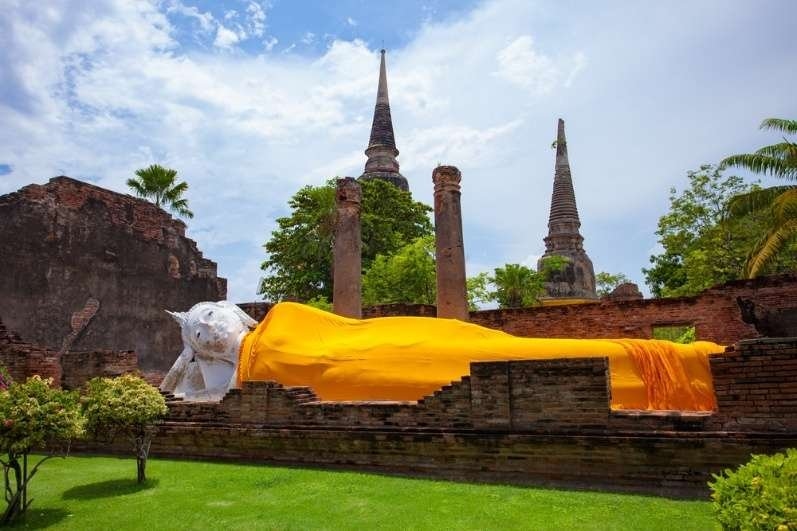 Large reclining Buddha statue draped in a golden robe at Wat Yai Chai Mongkhon temple in Ayutthaya, Thailand.