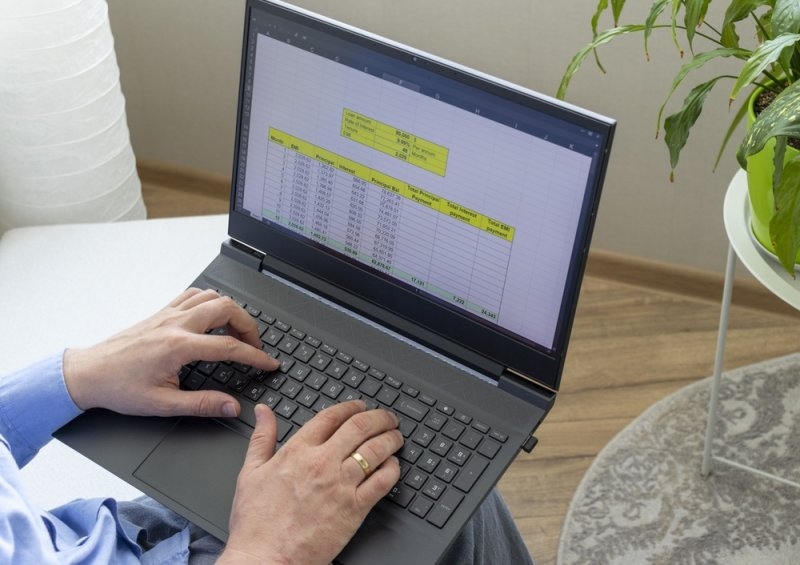 A man using laptop displaying a spreadsheet.