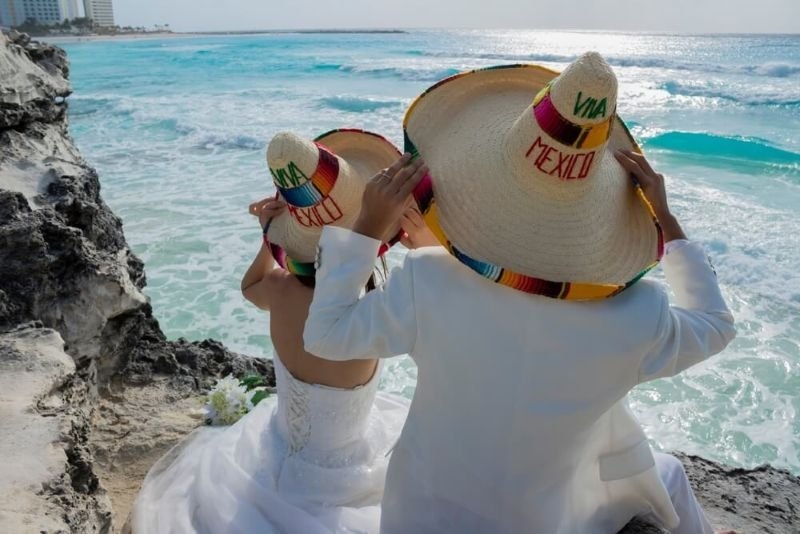 couple in wedding dresses modeling with Mexican hat 