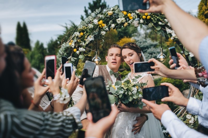 Wedding portrait of the groom, bride and guests in the park.