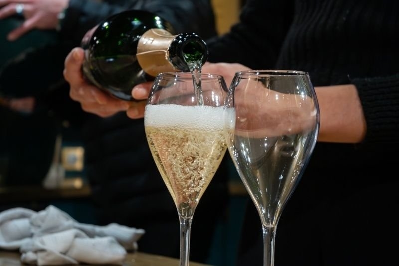 Sparkling champagne being poured into a flute glass beside an empty glass, capturing bubbles and celebration.