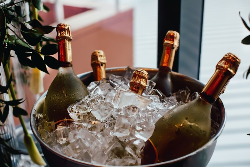 Several chilled wine bottles sitting in a bucket filled with ice.