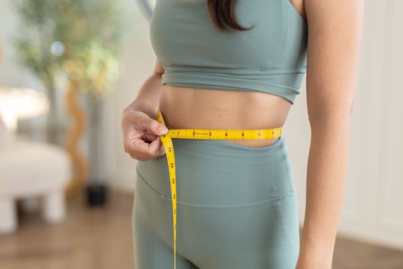 women measuring her waist to check the impact of workout for weight loss
