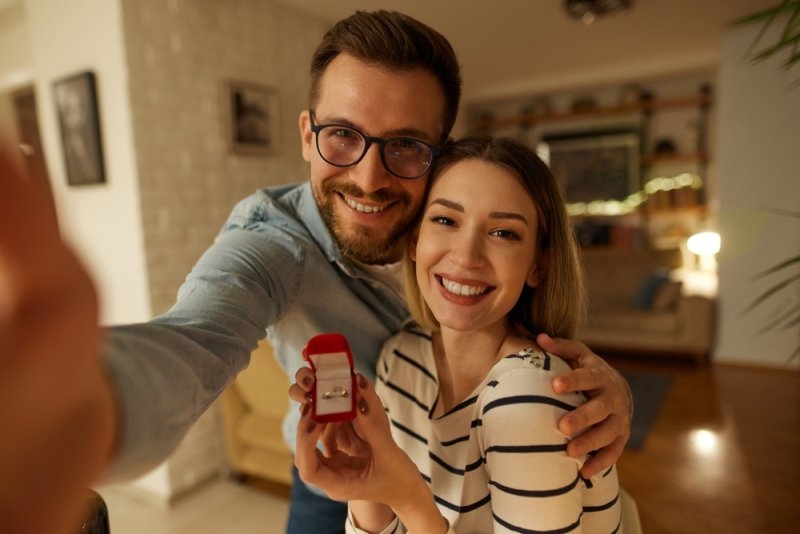 young couple announcing their engagement with selfie