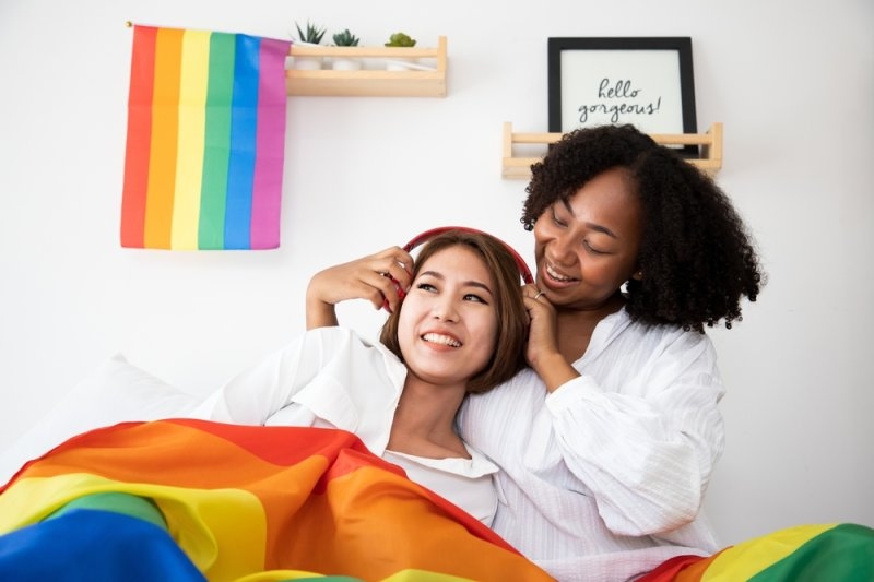 young gay women with Asian gay waving pride