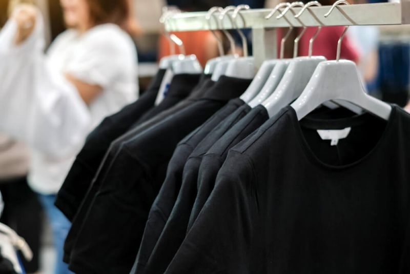  black t-shirts in hanger hanging in a department store
